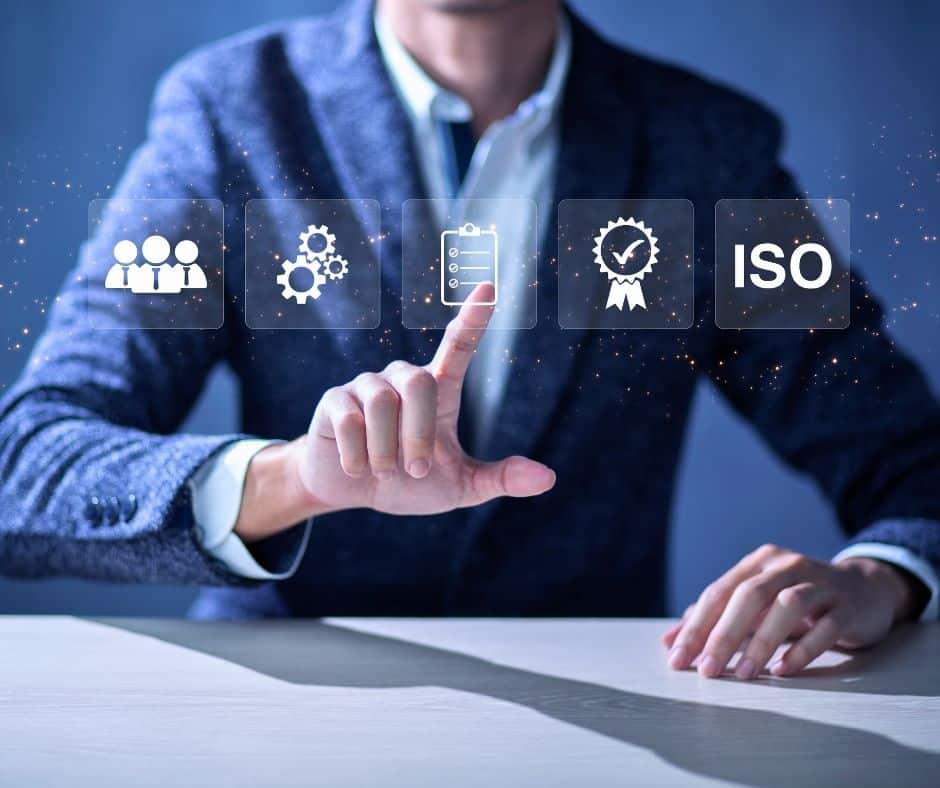 Businessperson in a suit taps floating icons representing teamwork, settings, checklist, a quality seal, and ISO standards.
